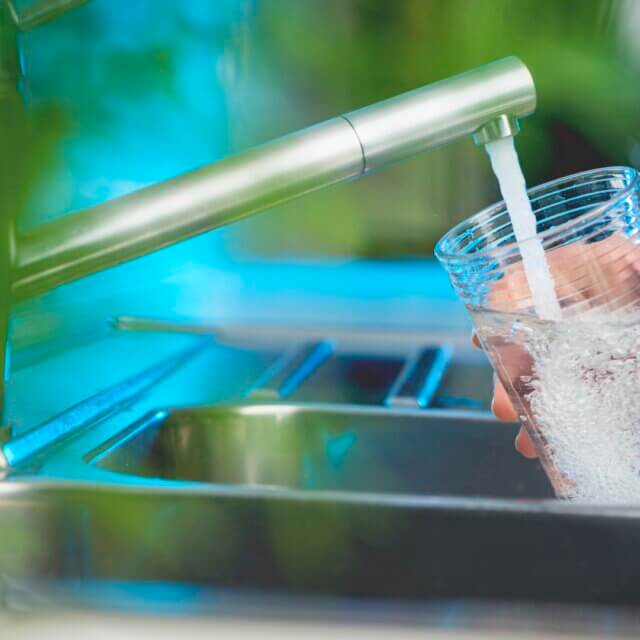 Woman filling a glass of water.